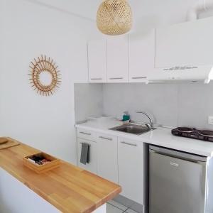 佩科霍里Villa Thalassa Apartments的白色的厨房配有白色橱柜和水槽