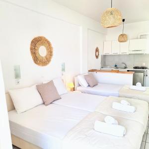 佩科霍里Villa Thalassa Apartments的带厨房的客房内的2张白色床
