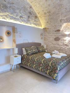 奥斯图尼Eureka luxury room的一间卧室设有一张床和石墙