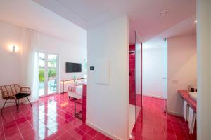 伊斯基亚Hotel Villa Durrueli Resort & Spa的铺有红色瓷砖地板的浴室和卧室