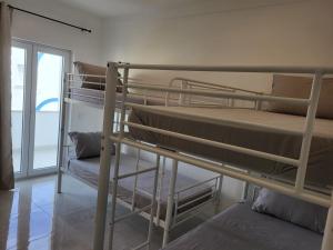 波尔蒂芒HostelCCPortimão的带窗户的客房内的两张双层床
