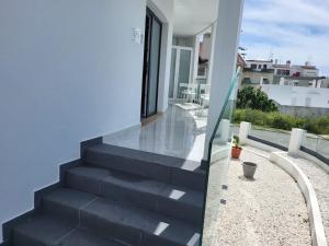 波尔蒂芒HostelCCPortimão的阳台设有楼梯,享有房屋美景