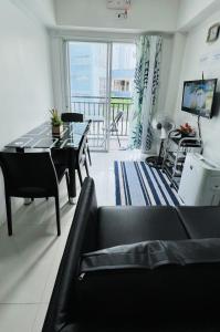 碧瑶Krystal Claine Homestay-BURNHAM HILL的客厅配有黑色沙发和桌子