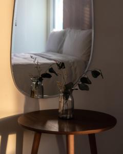 马公木子寓所 Moozhouse的木桌上方的镜子,上面有花瓶