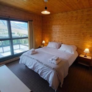 拉斯莱尼亚斯Apartur Las Leñas的一间卧室设有一张带木墙的大床