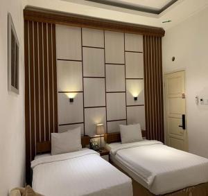 茂物Chevilly Resort & Camp的客房设有两张床和带镜子的墙壁。