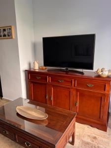 赫雷斯-德拉弗龙特拉Jerez, zona norte, Cadiz, España的木制梳妆台上方的电视,配有咖啡桌