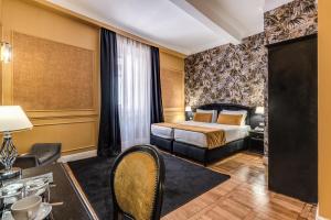 罗马Relais Fontana Di Trevi Hotel的配有一张床和一张书桌的酒店客房