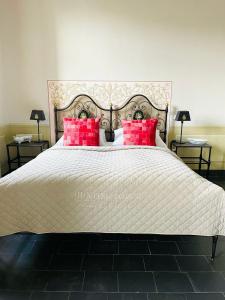 梅森索倪姿酒店的一间卧室配有一张带红色枕头的大床