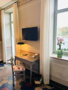 梅森索倪姿酒店的客房设有书桌、电视和窗户。