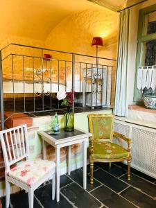 梅森索倪姿酒店的门廊配有两把椅子、一张桌子和一张床