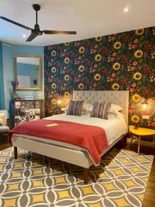 埃梅Maison Belmont Eymet的一间卧室设有一张带花卉墙壁的大床