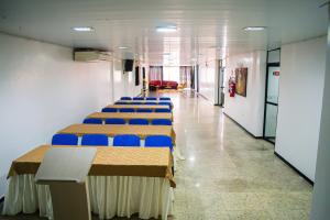 阿拉皮拉卡Hotel Pequeno Principe的走廊里一排带蓝色椅子的桌子