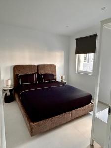 蒙斯Phoenix garden的一间卧室配有一张大床、黑色床单和窗户。