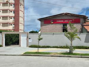 福塔莱萨Pousada Arco Iris Fortaleza的一座建筑,上面有读到破碎箭头的标志