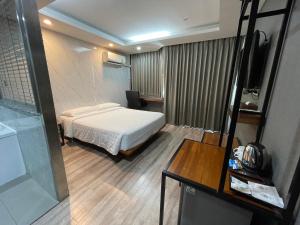 曼谷Bangkok City Link Hotel的酒店客房配有一张床铺和一张桌子。