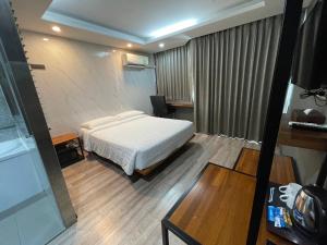 曼谷Bangkok City Link Hotel的一间卧室配有一张床、一张桌子和一张桌子