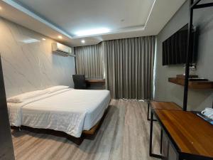 曼谷Bangkok City Link Hotel的酒店客房,配有床和电视