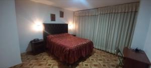 塔克纳HOTEL F0NTEs GLOBAL的一间卧室配有一张红色床罩的床