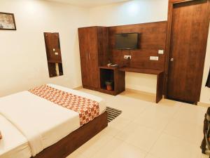 新德里Hotel King Plaza Near Delhi Airport的一间卧室配有一张床和一台平面电视