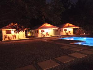苏丹巴特利Torch Ginger Homestay的几个帐篷,晚上设有一个游泳池
