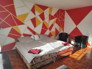 豪伊杜索博斯洛Szaffi apartman的一间卧室配有一张带彩色墙壁的床