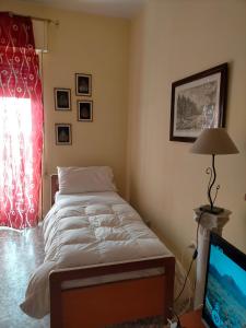 锡拉库扎Sleep In Sicily的一间卧室配有一张床、一盏灯和电视