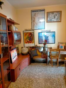 锡拉库扎Sleep In Sicily的客厅配有桌子和椅子,墙上挂有图片
