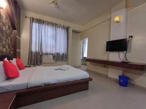 迪马普尔Hotel Elegant的一间卧室设有一张带电视和窗户的床。