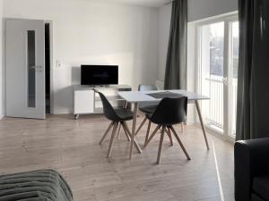 雷根斯堡Board Inn - Haus Regensburg的客厅配有桌椅和电视。
