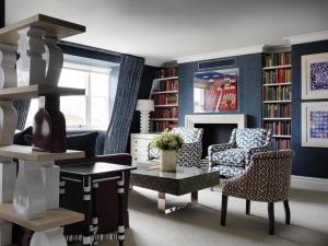 伦敦菲尔姆戴尔酒店集团夏洛特街酒店的客厅拥有蓝色的墙壁和桌椅