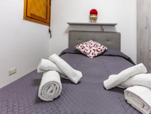 马里纳·迪·波迪斯科Portisco Living的一间卧室配有带毛巾的床
