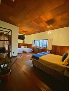 克萨尔特南戈Hotel Muchá的一间卧室设有一张大床和木制天花板