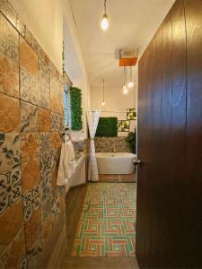 克萨尔特南戈Hotel Muchá的带浴缸、水槽和门的浴室