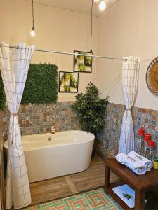 克萨尔特南戈Hotel Muchá的带浴缸和桌子的浴室