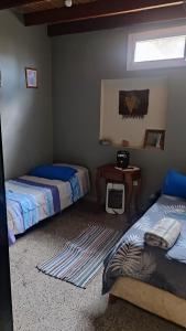 卡法亚特Casa Manipa -3 dormitorios的一间卧室设有两张床、一张桌子和一个窗口