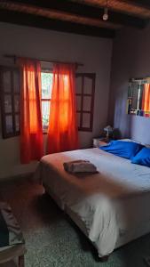 卡法亚特Casa Manipa -3 dormitorios的一间卧室配有带橙色窗帘的大床