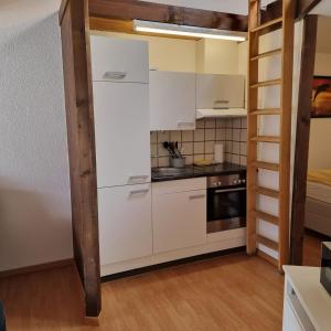 因特拉肯Brienz Strasse的厨房配有白色橱柜和炉灶。
