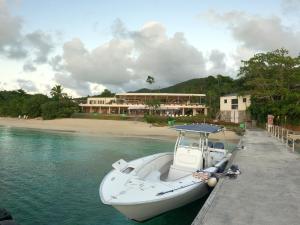 EnighedBeautiful Honeymoon Suite at Sunset Serenade的一艘船停靠在海滩旁边的水中