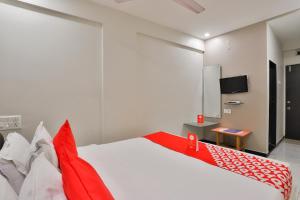 拉杰果德OYO Nova Hotel Nildeep的卧室配有红色和白色的床和电视。