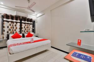 拉杰果德OYO Nova Hotel Nildeep的一间卧室配有一张带红色枕头的大床