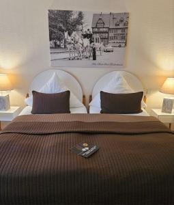 巴特弗兰肯豪森图林根霍夫酒店的一间卧室配有两张床,床上配有遥控器