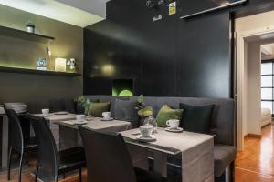 卡利亚里Martini Rooms Castello的用餐室设有桌椅和黑色墙壁
