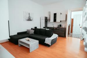 维也纳Raimond Apartment Ottakringer Top 10的客厅配有黑色沙发和桌子