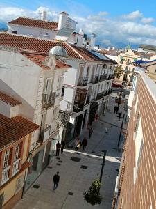 贝莱斯Los Maestros: ático en el centro de Vélez-Málaga的一群人沿着街道走着,街道上有许多建筑