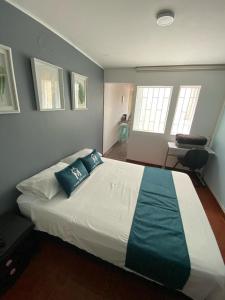 波哥大Hotel Boutique Casa Magaly的卧室配有带蓝色枕头的大型白色床