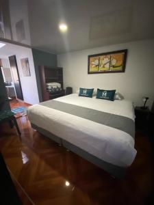 波哥大Hotel Boutique Casa Magaly的卧室配有一张带两个枕头的大白色床