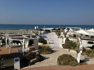 奥斯蒂亚·安提卡奥斯蒂亚度假屋的海滩上设有桌子和遮阳伞,还有大海