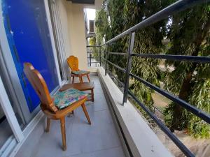 蒙巴萨Glo stays的两把椅子坐在房子的阳台上