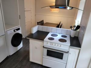 阿森斯Skrædderens hus的小厨房配有炉灶和洗碗机。
